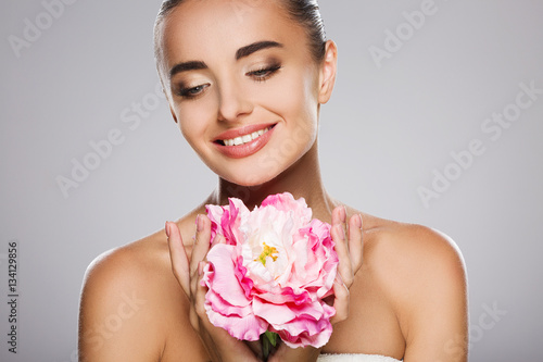 Beauty portrait of woman with big pink flower