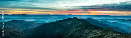 Panorama with blue mountains and hills at sunset