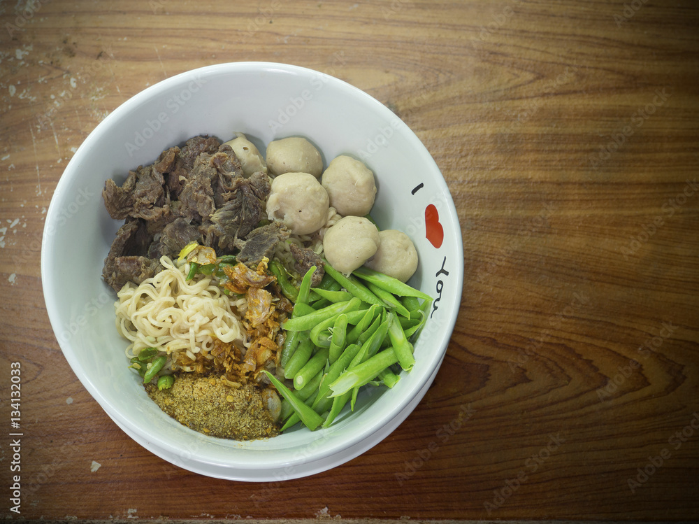 Instant nooddles with beef and meatball on wooden table Instant nooddles with beef and meatball on wooden table