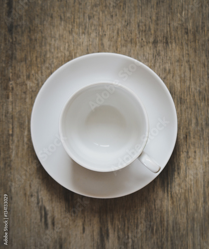 empty cup for coffee or tea on a plate on a wooden background