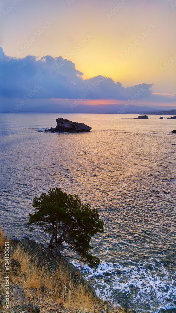 Naklejka premium Cyprus beautiful sunrise at the sea with rocks and cloudy sky, natural panoramic background. Summer vacation concept
