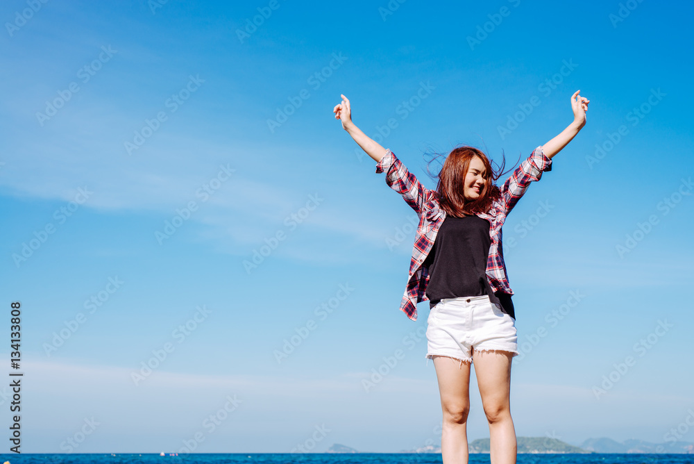 Woman relaxing at beach enjoying summer freedom with open arms and hair in the wind by the water seaside. Asian girl on summer travel holidays vacation outside. Vintage effect style pictures. Woman relaxing at beach enjoying summer freedom with open arms and hair in the wind by the water seaside. Asian girl on summer travel holidays vacation outside. Vintage effect style pictures.