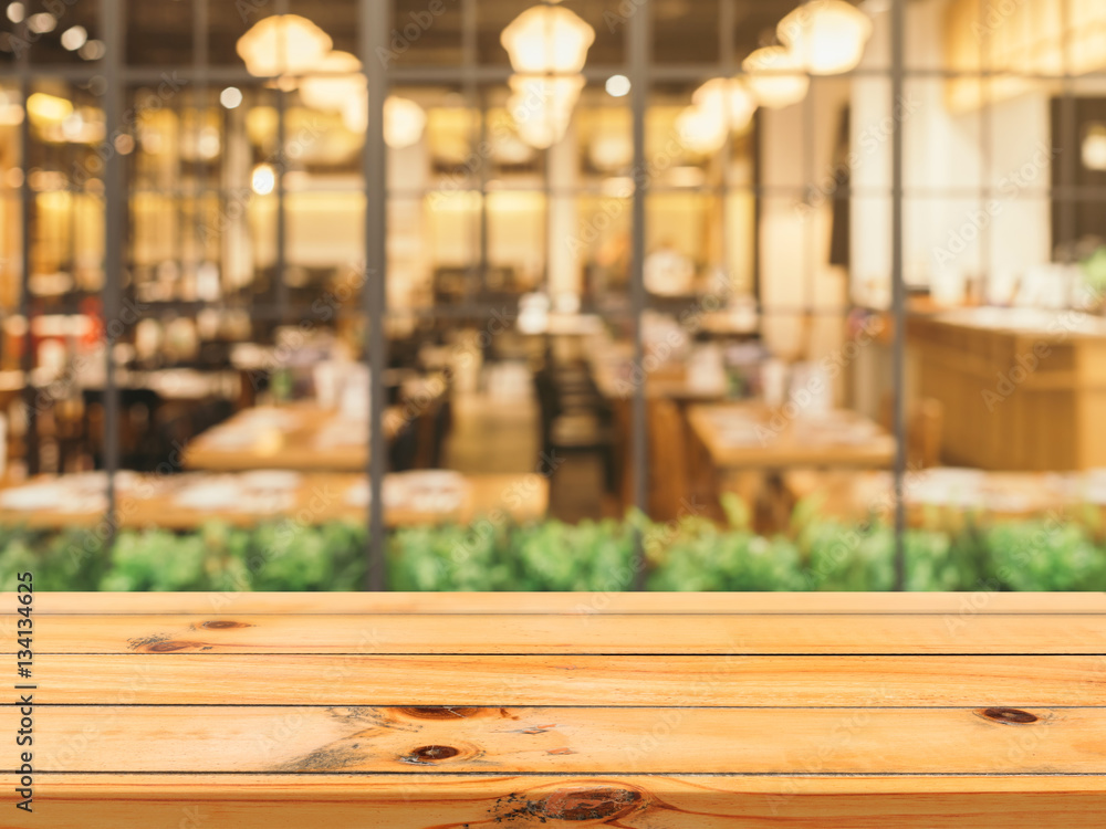 Wooden board empty table top on of blurred background. Perspective brown wood table over blur in coffee shop background - can be used mock up for montage products display or design key visual layout. Wooden board empty table top on of blurred background. Perspective brown wood table over blur in coffee shop background - can be used mock up for montage products display or design key visual layout.