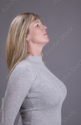 Portrait of a busty middle aged attractive woman wearing a grey top  Stock-Foto | Adobe Stock