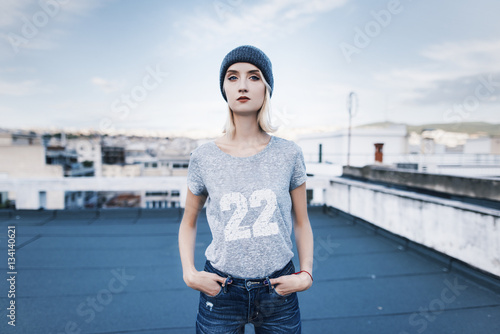 young woman is posing on a rooftop wearing street urban style outfit