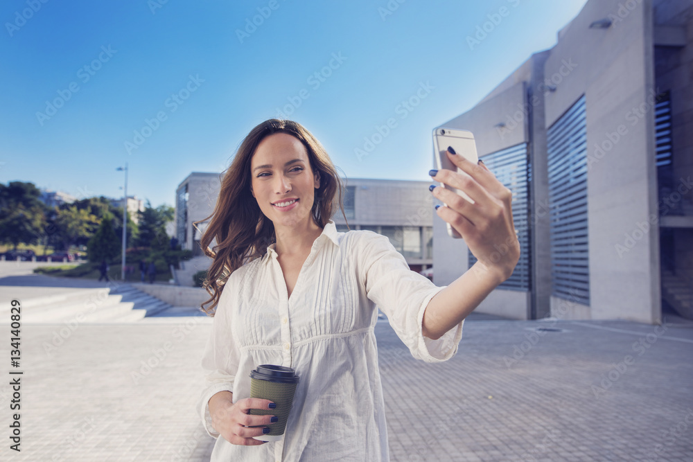 woman is using an app in her smartphone device to take a self portrait
