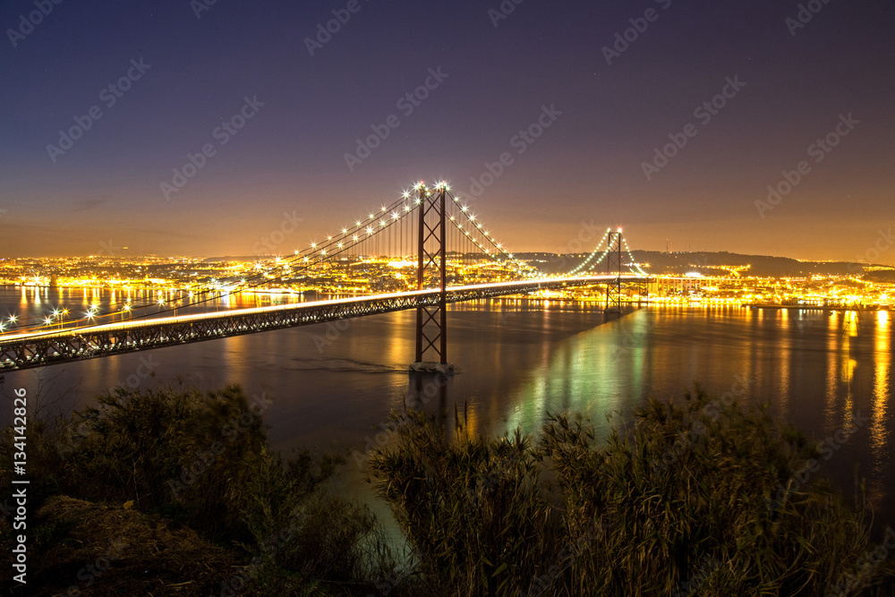 Sonnenuntergang hinter der Ponte 25 de Abril, die Brücke über den Tejo in Lissabon ( mit Industriehafen im Vordergrund) Sonnenuntergang hinter der Ponte 25 de Abril, die Brücke über den Tejo in Lissabon ( mit Industriehafen im Vordergrund)