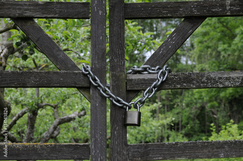 kette und vorhängeschloss an gattertor