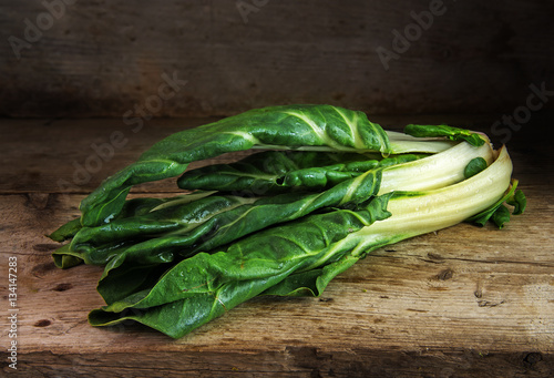 Chard or mangold, raw organic leaf vegetable on a rustic wooden table photo