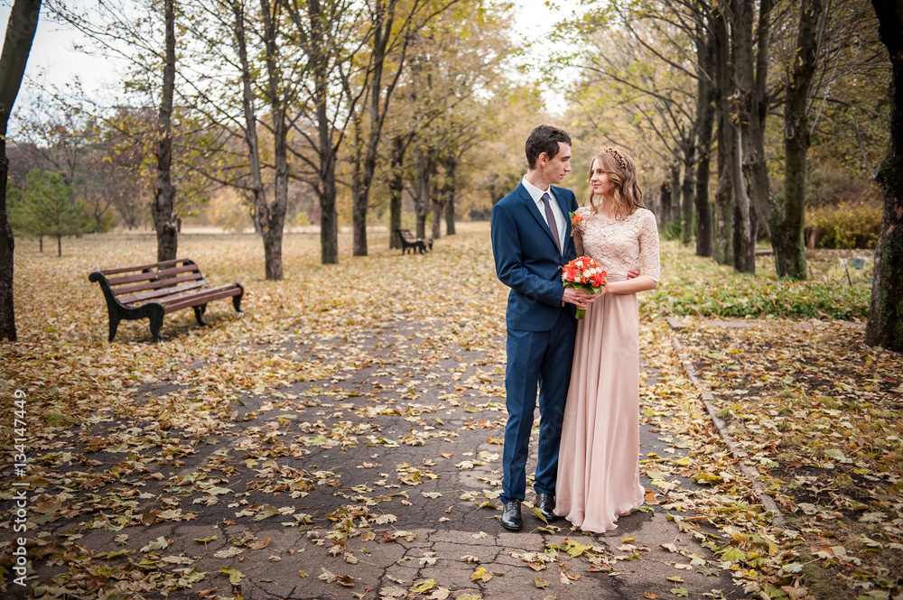 Fototapeta premium Bride and groom hugging in a forest in the autumn forest, weddin