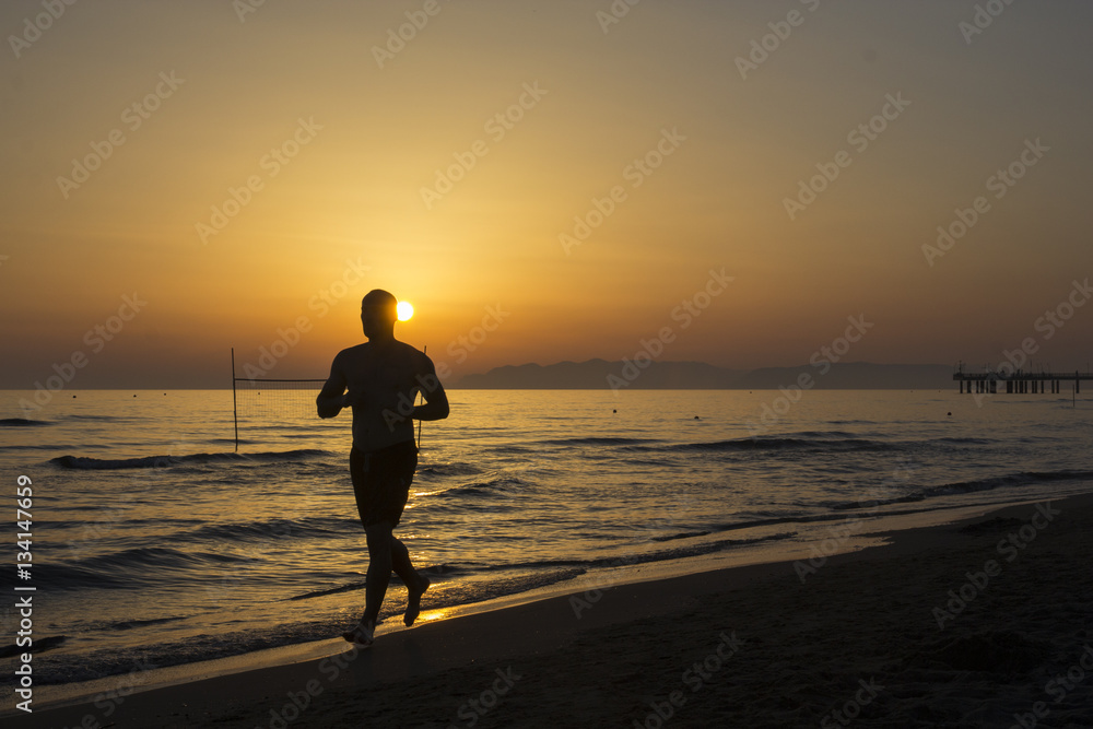 Läufer am Strand bei Sonnenuntergang