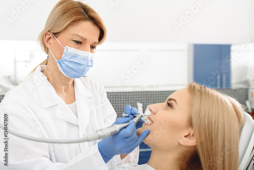 Odontologist creating brilliant smile of female