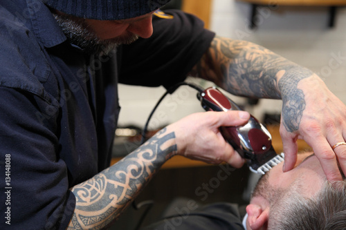Men s hairstyling and haircutting in a barber shop or hair salon.