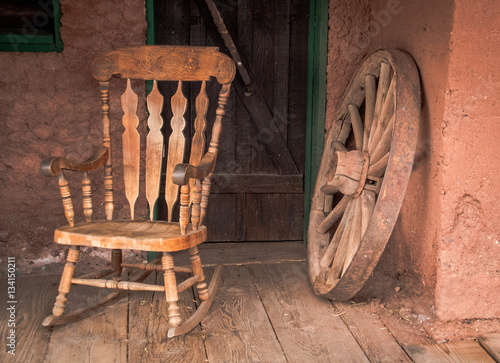 Obraz na plátne Rocking chair and old wooden wheel in Calico ghost town in USA