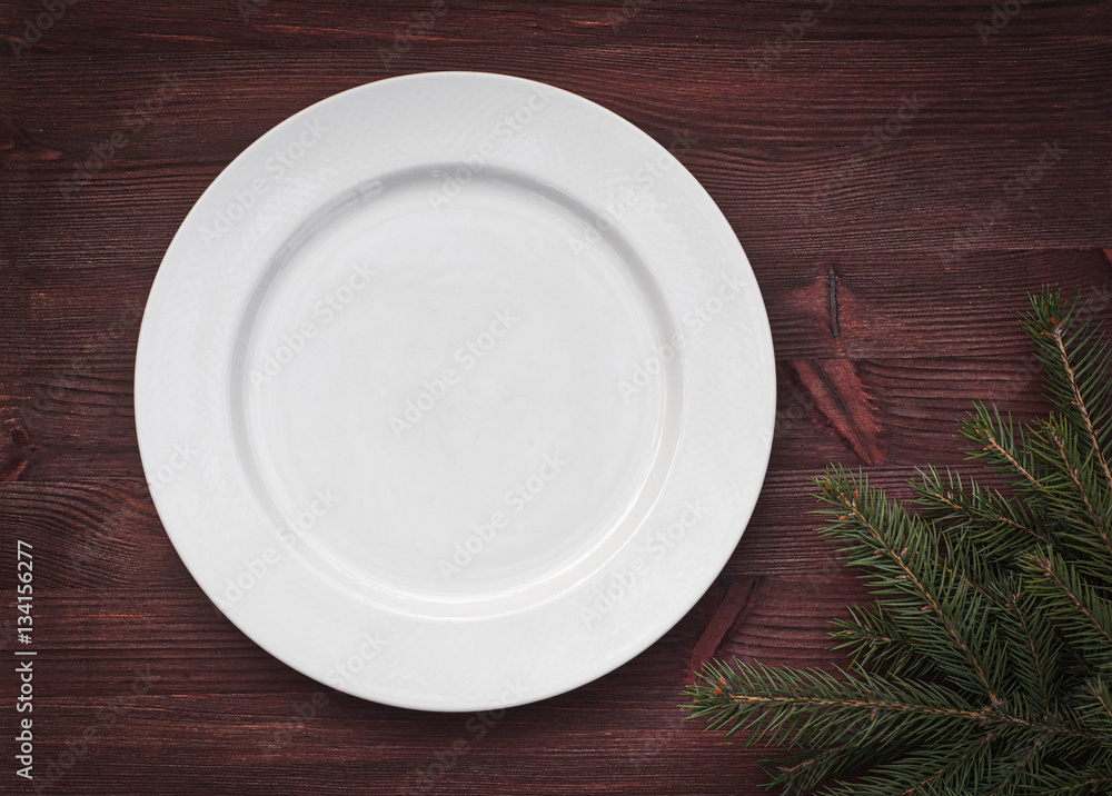 White empty plate on brown wooden surface White empty plate on brown wooden surface