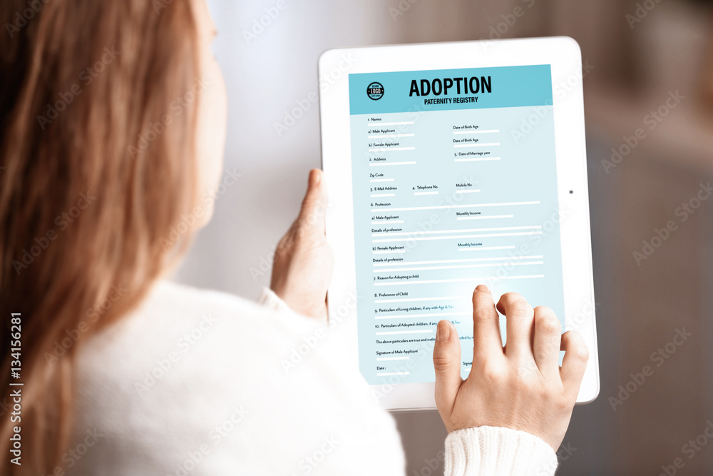 Adoption concept. Woman filling in paternity form on tablet Adoption concept. Woman filling in paternity form on tablet