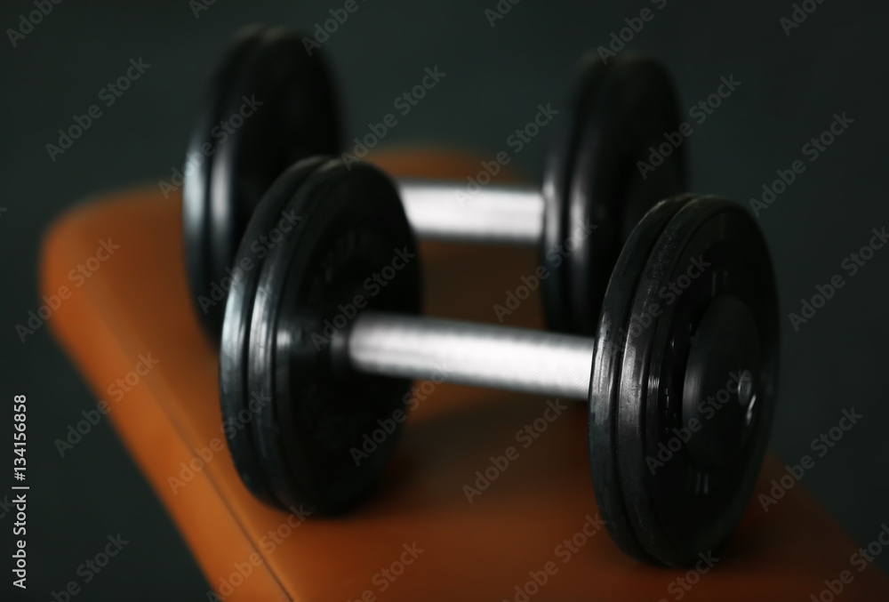 Dumbbells in gym on blurred background, close up