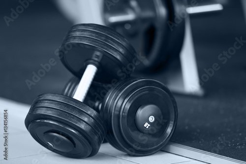 Two dumbbells on floor in gym, close up