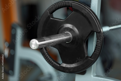 Barbell on rack in gym, close up