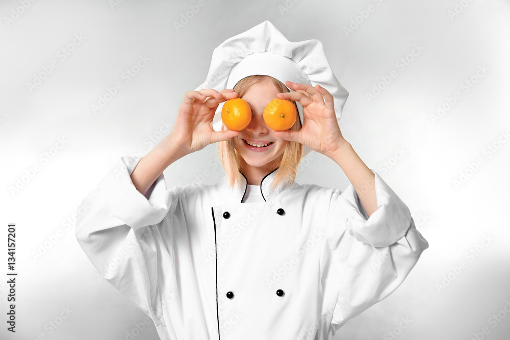 Cute girl in chef uniform on light background Cute girl in chef uniform on light background