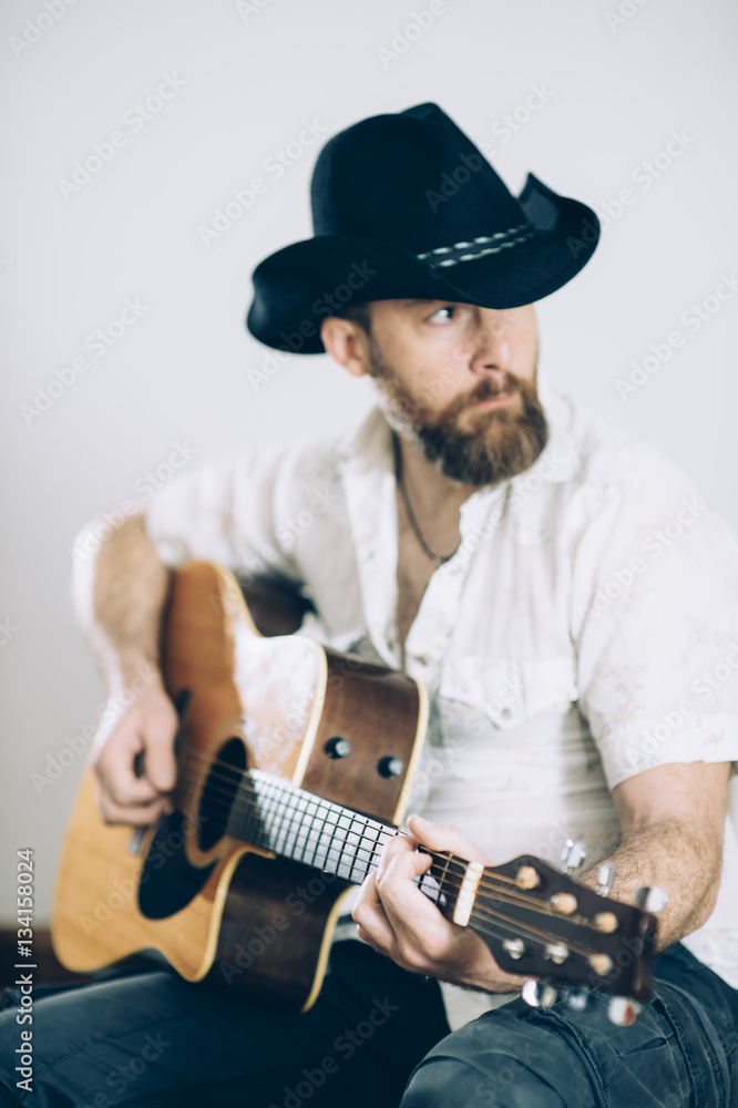 Obraz premium Cowboy touching the acoustic guitar