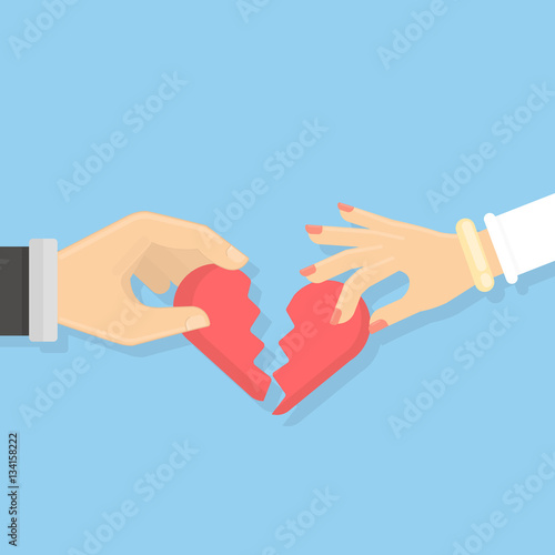Broken heart concept. Male and female hands hold pieces of broken heart. Idea of divorce and break up.