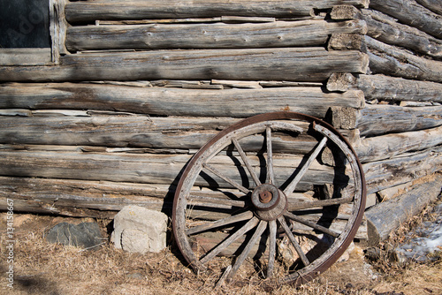 Log Cabin with wagon wheel background