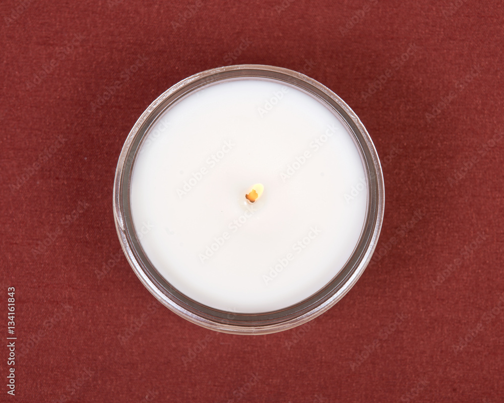 Soy candle in glass jar on red fabric background Soy candle in glass jar on red fabric background