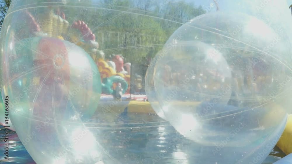 The big inflatable balls floating on the water in the pool outdoor The big inflatable balls floating on the water in the pool outdoor