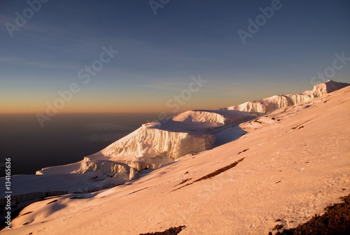 Orange glow across the upper slopes of Mt Kilimanjaro at sunrise. 