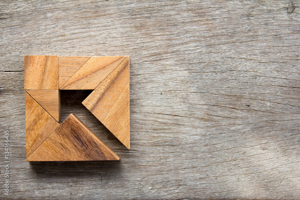 Tangram puzzle as arrow in square shape on wooden background (Co Tangram puzzle as arrow in square shape on wooden background (Co