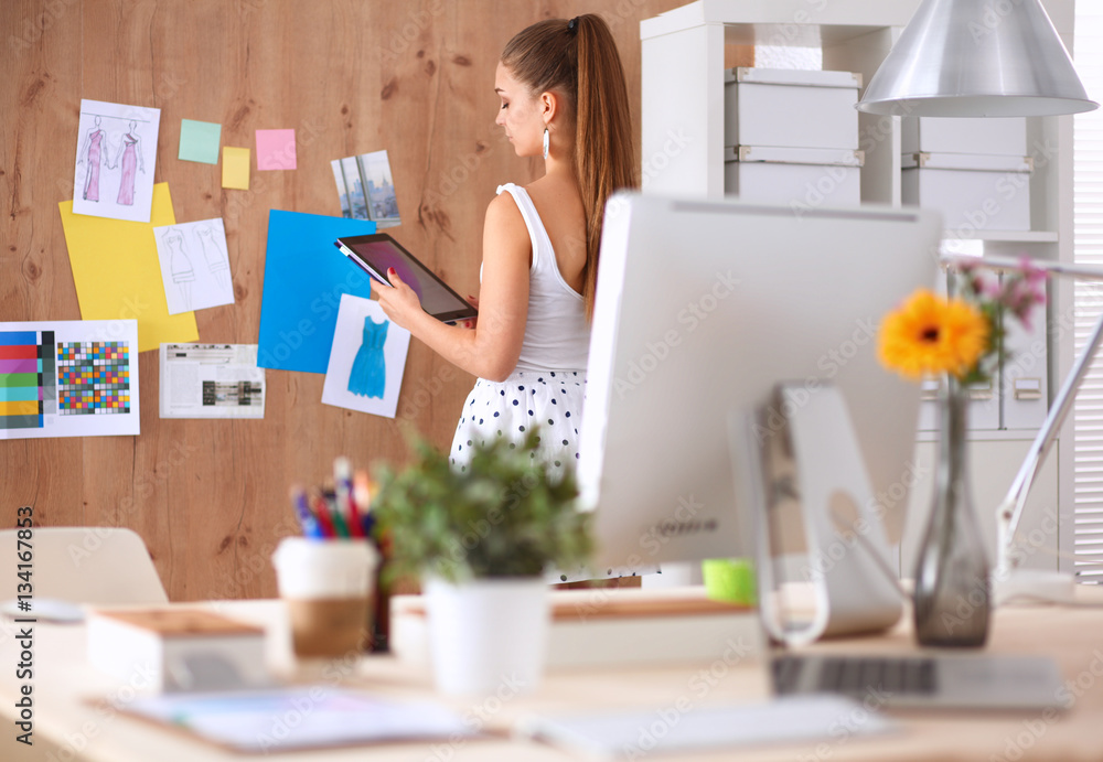Young woman working in office, standing at desk Young woman working in office, standing at desk