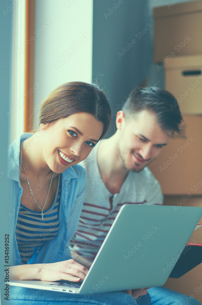 Young couple sitting on the floor of their new apartment Young couple sitting on the floor of their new apartment