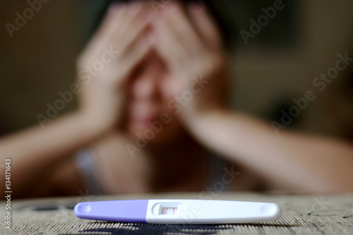 serious woman with a positive pregnancy test