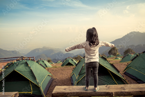 back view of asian girl expand her arms in camping 