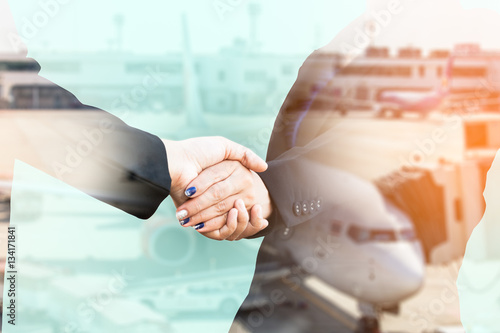 Double exposure of businesspeople handshake with aeroplane