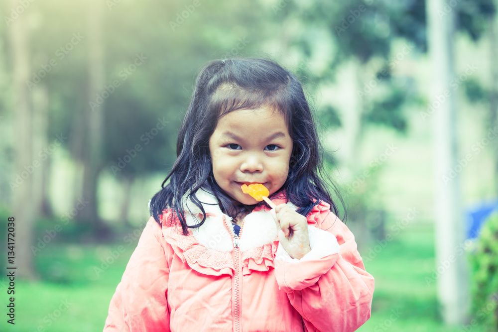 Cute asian little girl is eating ice-cream in the park Cute asian little girl is eating ice-cream in the park