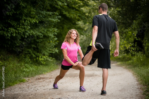 Stretching warm-up exercise before starting to run by couple