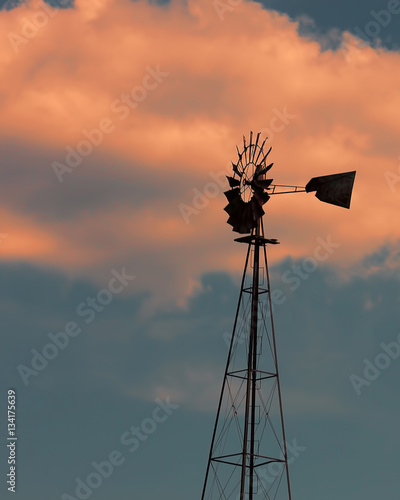 A windmill silhouette with beautiful sky and clouds.