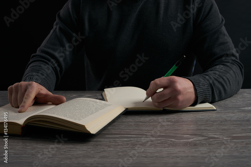 left-hander man studying at wooden table
