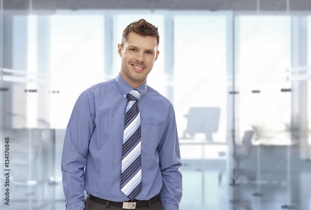 Portrait of happy young businessman at office