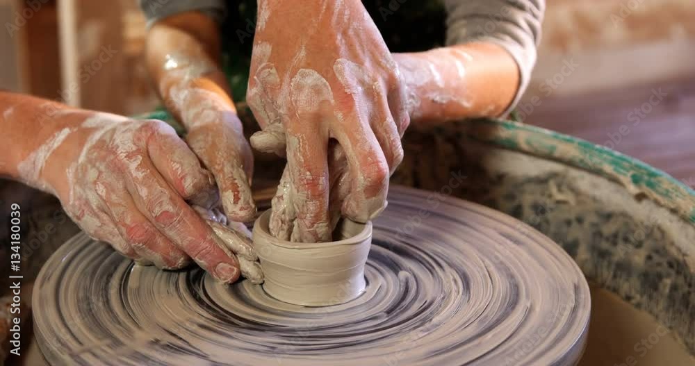 Female potter assisting a girl Female potter assisting a girl