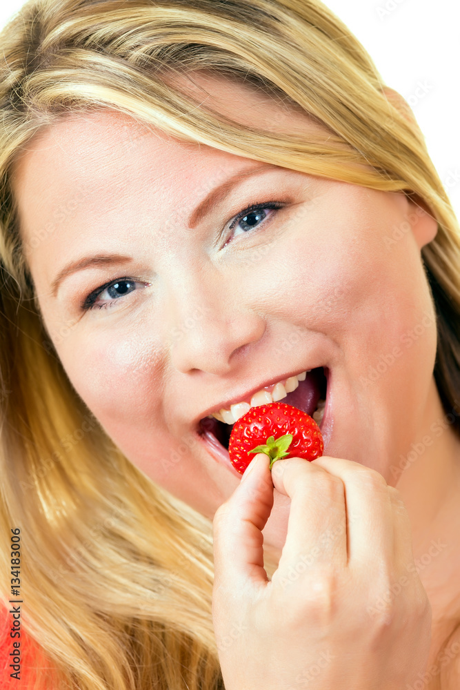 Young blond woman eating ripe strawberry. Young blond woman eating ripe strawberry.
