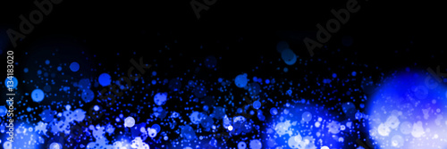 banner with bright blue bokeh effects in front of a black background