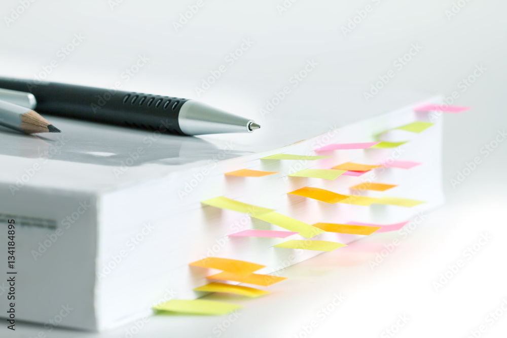 Obraz premium Close up White book marked by sticky note