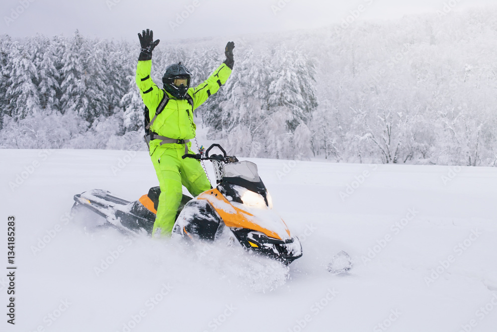 Athlete on a snowmobile moving in the forest