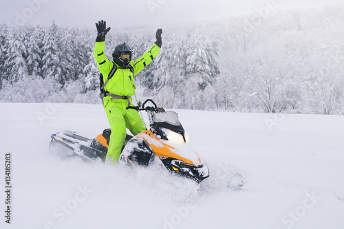 Athlete on a snowmobile moving in the forest