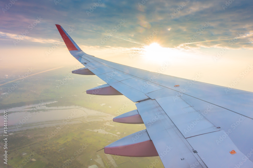 Wing of an airplane flying above the clouds at sunset . ( Filter Wing of an airplane flying above the clouds at sunset . ( Filter