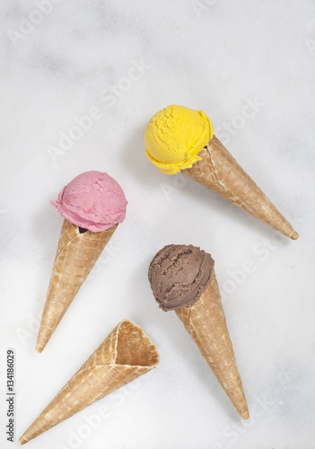 Various ice cream cones are on the marble surface.