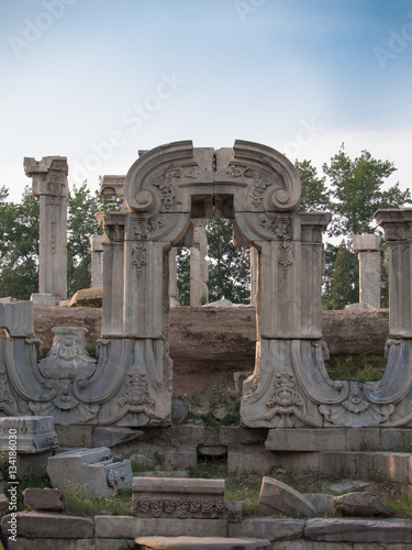Deserted ancient ruins of the Imperial Palace yuanmingyuan against a blue sky and trees © atomfotolia